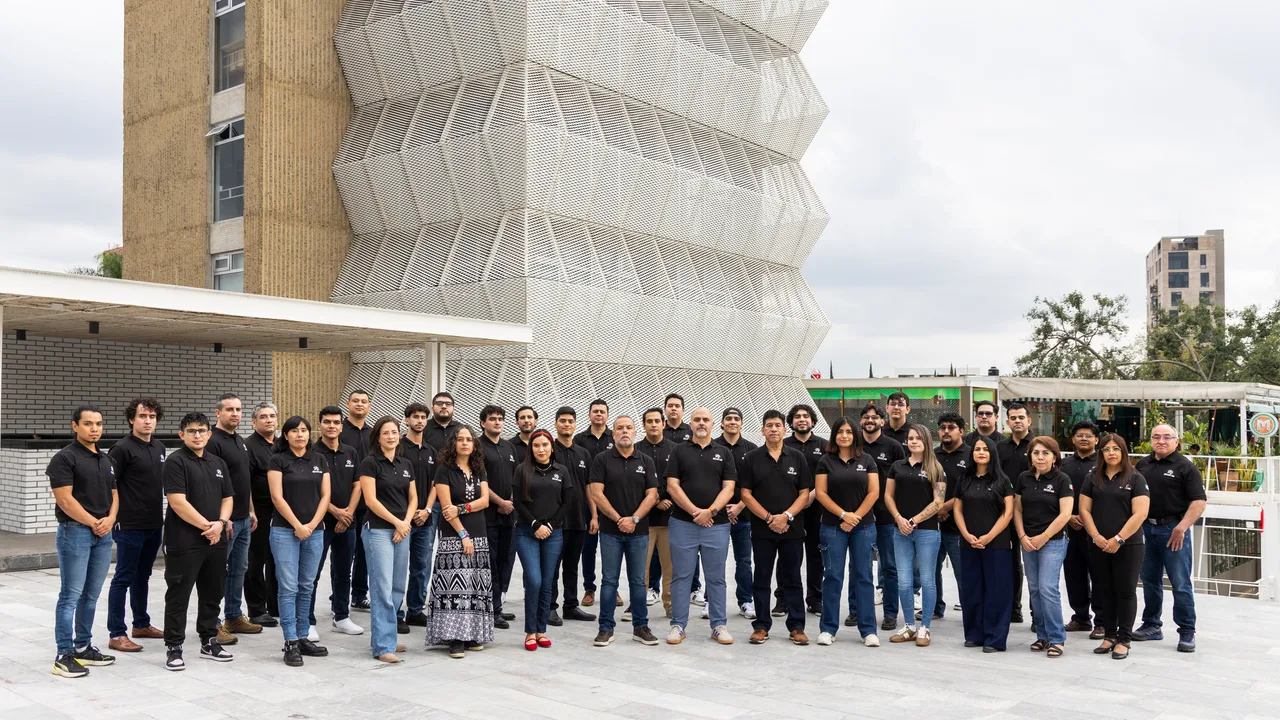Equipo SIGOB® en conjunto frente a la torre corporativa con fachada de celosía dorada